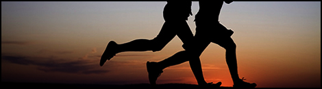 Young couple: man and  woman run together on a sunset on lake coast.  Silhouette.